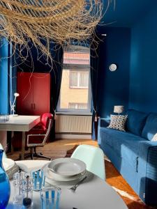 a living room with a blue couch and a table at CLS Große City Altbau Wohnung für 4 Personen mit XXL Dusche, neues Bad, Dielen, Schlafsofa 160x200 mit 20cm Matratze, Smart TV & schnellem WLAN in Hildesheim Ost, Nähe HAWK, Uni, Bosch, Ostbahnhof, A7 in Hildesheim