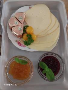 a bento box with a plate of cheese and sauce at Vorwerk Wehlen in Stadt Wehlen