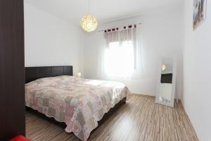 1 dormitorio con cama, ventana y espejo en Apartments Ivan en Trogir