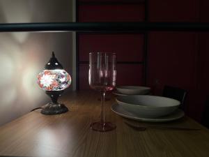 - une table avec un verre de vin et une lampe dans l'établissement HAREM romantic apartment, à Eger 5 autres photos