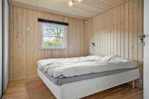 a bedroom with a bed in a wooden wall at C11148-Hemmet-Lappedykkervaenget-22 in Hemmet