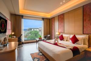 a hotel room with a bed and a large window at Sandoz Pribson Suites - 1 km from Golden Temple in Amritsar +72 photos