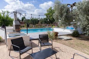a patio with two chairs and a swimming pool at Casa los Laureles in Pilas