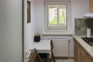 a small kitchen with a table and a window at Justin Ultra-Central Apartment in Galaţi +9 photos