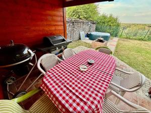 a picnic table with chairs and a grill on a patio at Vöröspart Vendégház in Kulcs