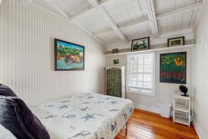 una camera da letto con letto e quadri alle pareti di Sunny oceanfront home with balcony, full kitchen, central AC, & washer/dryer a Summer Haven