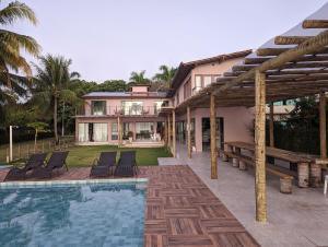 a house with a swimming pool in front of a house at Slater's House in Paripueira