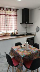 a kitchen with a table with a table cloth on it at Charmant appartement avec jardin in Figeac