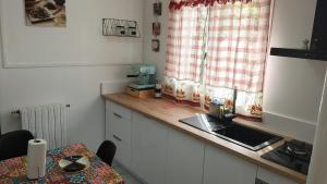 a kitchen with a counter and a sink and a window at Charmant appartement avec jardin in Figeac