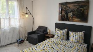 a bedroom with a bed and a chair at Charmant appartement avec jardin in Figeac +2 photos