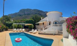 a house with a pool with a ball in the water at Unique villa piscine vue mer et montgo impasse privée in Denia
