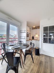 a kitchen and dining room with a table and chairs at 32 m2 appartement idéal famille avec parking privé in Berck-sur-Mer