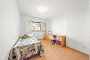 a bedroom with a bed and a desk and a computer at Apartamento confortable en Altea in Altea