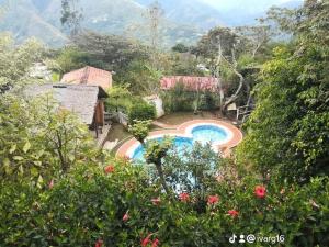 a resort with a swimming pool and mountains in the background at Moranegra - Casa y Campo in Coroico
