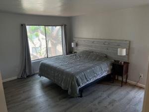a bedroom with a bed and a large window at Sunny Condo Steps from Sand in San Diego