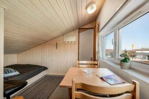 Una pequeña habitación con una cama, una mesa y una ventana. en C11567-Hemmet-Kirkehojvej-36-S3, en Hemmet