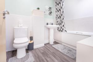 a white bathroom with a toilet and a sink at Etihad Stadium Stay for Contractors with Free Parking & Wifi Near The City Stays in Manchester +29 photos