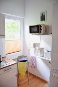a small kitchen with a stool in a kitchen at Ferienappartment in der City in Bremen +6 photos
