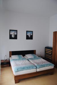 a bed in a bedroom with two pictures on the wall at Ferienappartment in der City in Bremen