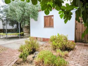 una casa bianca con una panchina gialla nel cortile di El Corral de la Higuera a Campofrío