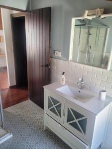 a bathroom with a white sink and a mirror at El Corral de la Higuera in Campofrío +30 photos
