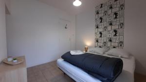a bedroom with a large blue bed with a wall at Maisons de vacances 6 pers proche plan d'eau in L'Aiguillon-la-Presqu'île