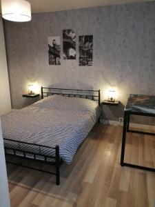 a bedroom with a bed with two tables and two lamps at Charmante petite maison de ville à 20 minutes de la mer in Giberville