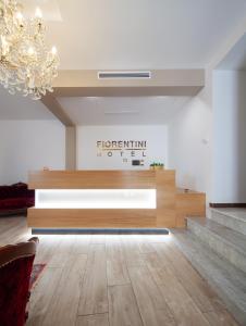 a living room with a chandelier and wooden floors at Palazzo Fiorentini Charme Hotel in Cariati