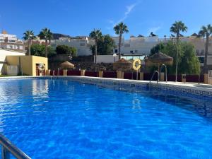 una gran piscina con agua azul en Confortable apartamento con garaje en Aguadulce, en Roquetas de Mar