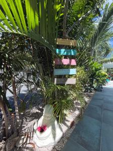 a palm tree sitting next to a white chair at Les Galets Sxm Luxury Lodges in Orient Bay