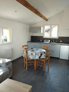 a kitchen with a table and chairs in a room at House on the edge of the forest in Dolomieux
