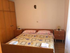a bedroom with a bed with two dressers and a bedspread at Guest House Attilia in Cres