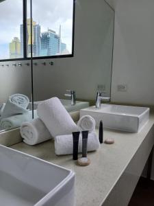 a bathroom with a sink and two towels on a counter at Hotel Mio Panamá in Panama City