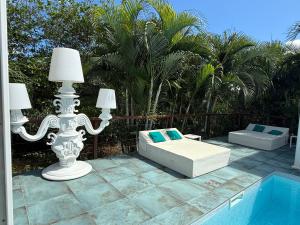 a patio with a bed and lamps next to a pool at Les Galets Sxm Luxury Lodges in Orient Bay