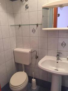 a bathroom with a toilet and a sink at Guest House Attilia in Cres