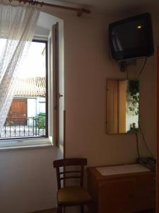 a room with a window and a tv and a chair at Guest House Attilia in Cres +16 photos