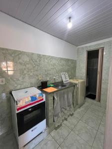 a kitchen with a sink and a counter top at Kitnet temporada mobiliada Beira Mar in Rio das Ostras