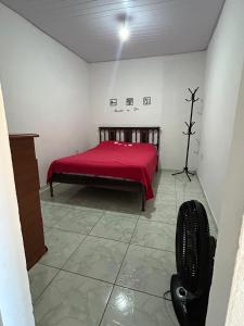 a bedroom with a bed with a red blanket at Kitnet temporada mobiliada Beira Mar in Rio das Ostras