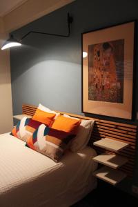 アヴェイロにあるFeelings Aveiro Apartmentのベッドルーム1室(ベッド1台付)が備わります。壁に絵が飾られています。