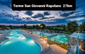 a view of a large swimming pool at night at Frattina1860 in Montisi