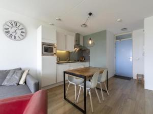a kitchen and living room with a table and chairs at Apartment near Groote Keeten Beach in Groote Keeten +10 photos
