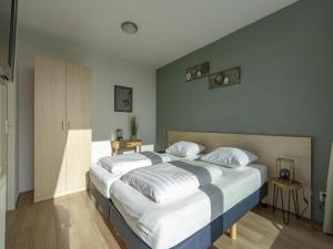 a bedroom with a large bed with white pillows at Apartment near Groote Keeten Beach in Groote Keeten