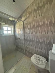 a bathroom with a shower and a toilet at casarosaencantada -villaencantorosa in Gramado