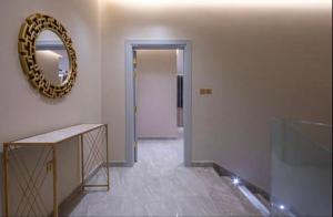 a hallway with a mirror on the wall and a door at كيونا للأجنحة والفلل - Kyona suites & villas in Jeddah