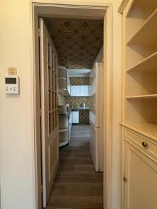 a hallway leading to a kitchen with white appliances at Lumiére Cedofeita in Bicas