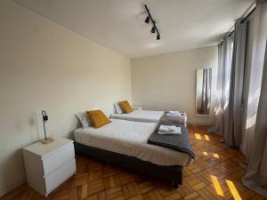 a bedroom with a bed and a dresser in it at Lumiére Cedofeita in Bicas