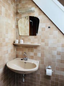 a bathroom with a sink and a mirror at Ferienwohnung Klahn Neue Tiefe in Neue Tiefe Fehmarn +4 photos