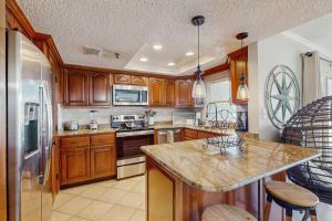 a kitchen with wooden cabinets and a granite counter top at Anglers Cove 608 in St. Pete Beach