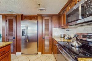 a kitchen with a stainless steel refrigerator and cabinets at Anglers Cove 608 in St. Pete Beach +17 photos