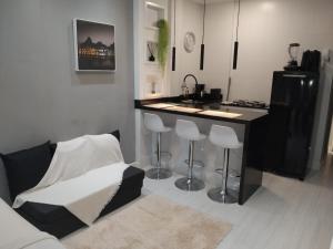 a kitchen with a counter and a bar with stools at Loft Copacabana Mar in Rio de Janeiro